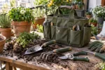 Heavy duty garden tool set with canvas carry bag, stainless steel hand tools, pruning shears, gloves, and trowels in a sunny backyard garden.